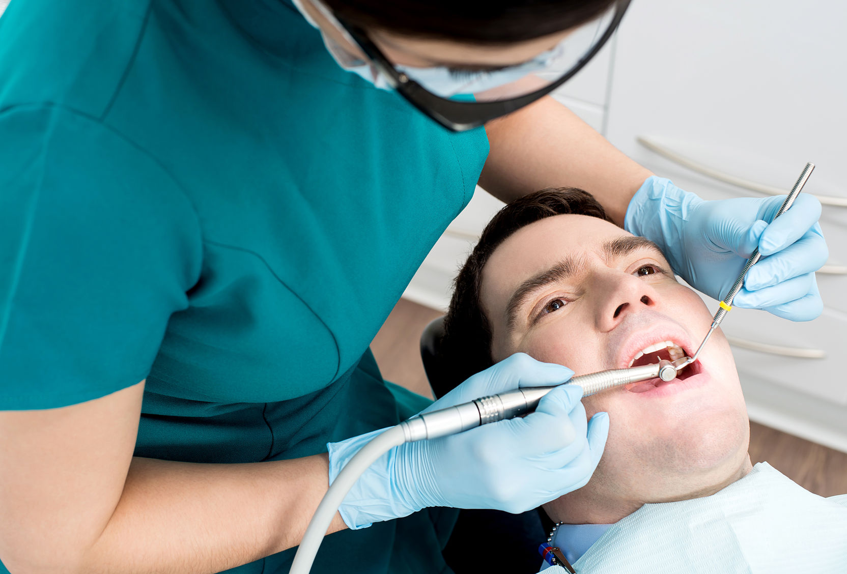 male with open mouth during oral checkup at dentist